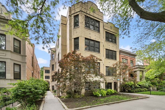 Front view of a multi-story brick building with large windows.
