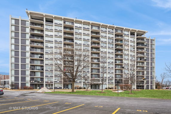 Front view of a multi-story apartment building with balconies.