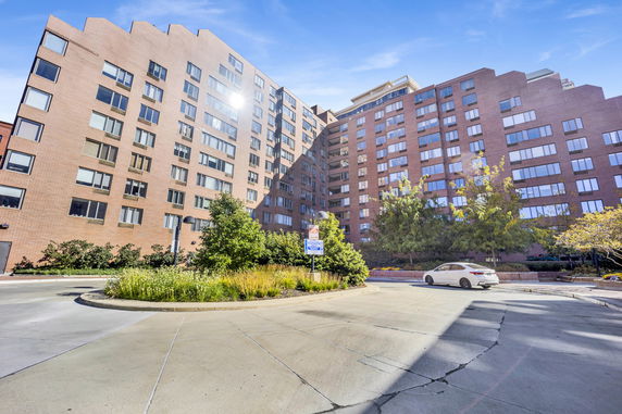 Front view of a multi-story apartment building with a circular driveway.