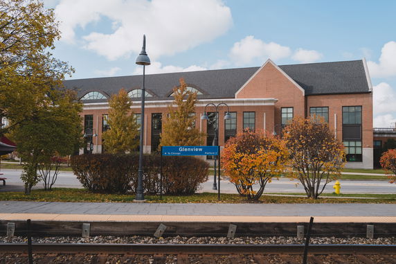 Front view of a two-story brick building with large windows and a sloped roof.