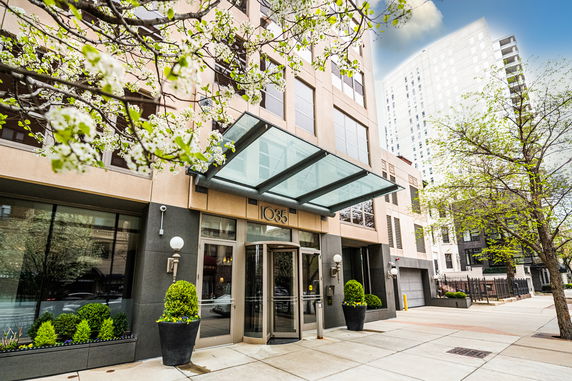 Front view of a building entrance with glass awning and revolving door.
