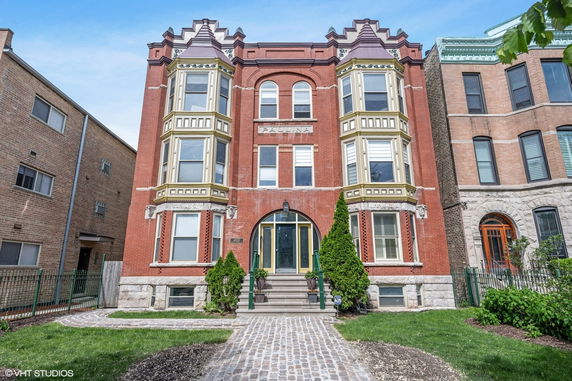 Front view of a multi-story brick building with decorative windows.