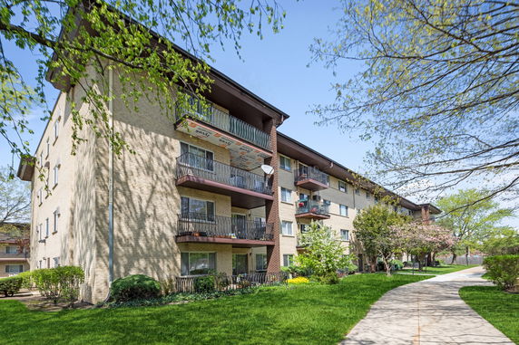 Front view of a multi-story apartment building with balconies.