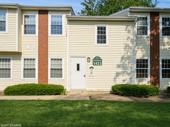 Front view of a two-story residential building with brick and siding exterior.