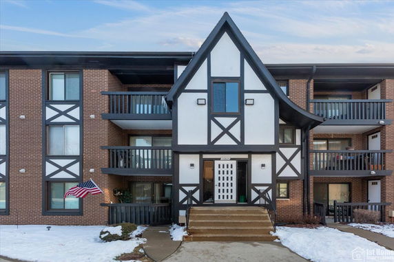 Front view of a multi-story building with a Tudor-style facade and balconies.