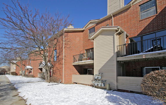 Front view of a multi-story brick building with balconies.