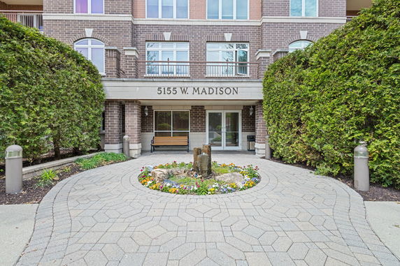 Front view of a multi-story brick building with central entrance and signage.