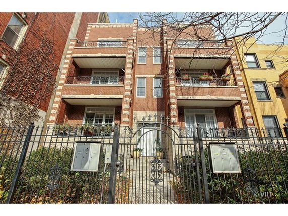 Front view of a three-story apartment building with balconies.