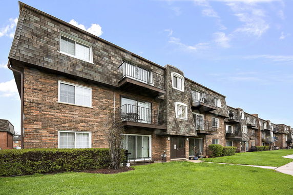 Front view of a three-story apartment building with balconies.