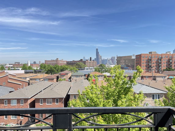Panoramic view of urban rooftops and a city skyline in the distance.