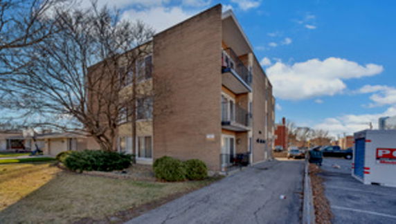 Front view of a multi-story brick building with balconies.