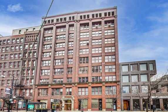 Front view of a multi-story brick building with multiple windows.