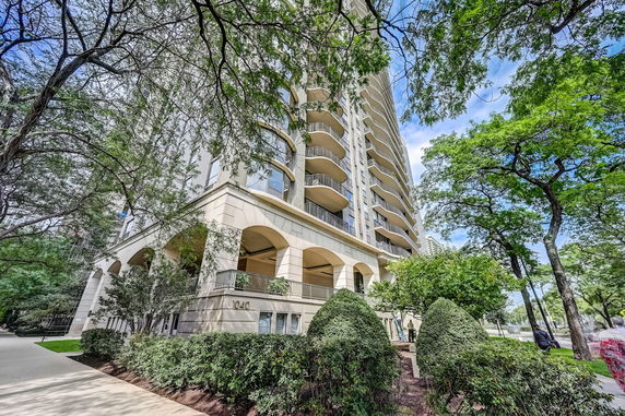 Front view of a multi-story building with balconies and arched walkways.