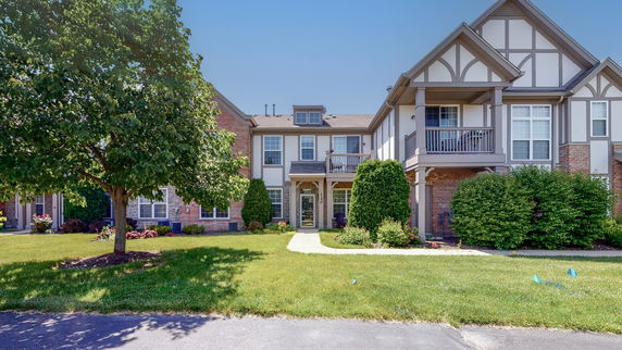 Front view of a multi-story house with large windows and balconies.