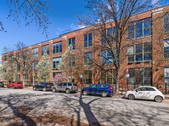 Front view of a large three-story brick building with multiple windows.