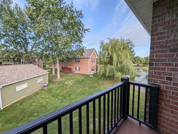 View from a balcony overlooking surrounding houses and greenery.