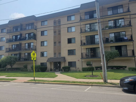 Front view of a multi-story apartment building with balconies.