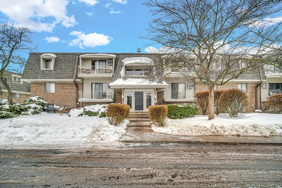 Front view of a two-story building with balconies and a snowy landscape.