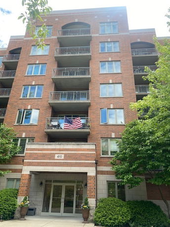 Front view of a multi-story brick apartment building with balconies.