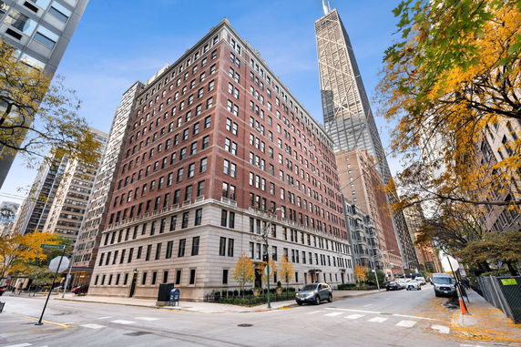 Front view of a multi-story red brick building on a city street.