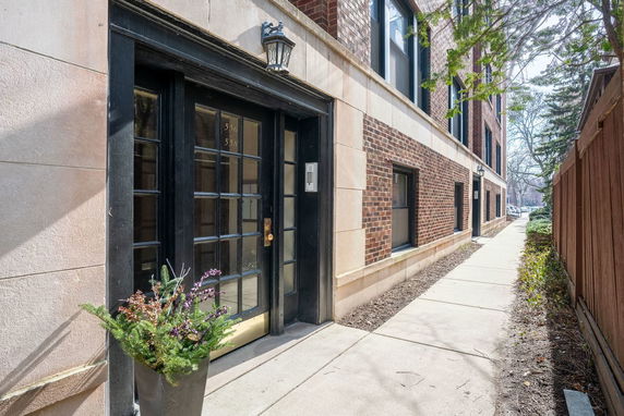 Side view of a brick building with black-framed entrance and windows.