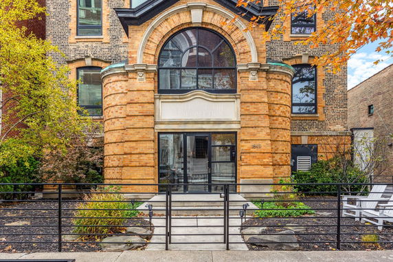 Front view of a brick building with large arched windows.