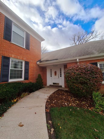 Front view of a house with a brick facade and white door.