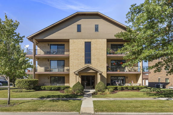 Front view of a multi-story apartment building with balconies.