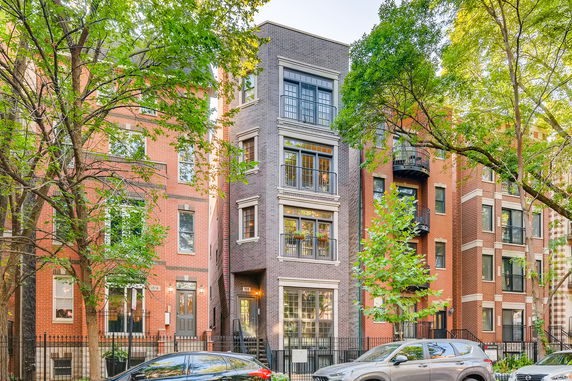 Front view of a multi-story urban building with brick exterior and large windows.