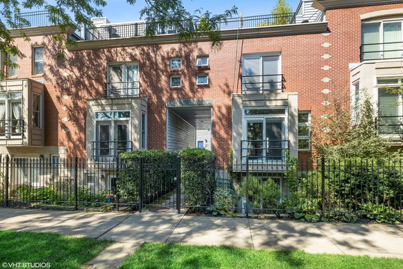 Front view of a townhouse with a brick facade and multiple windows.