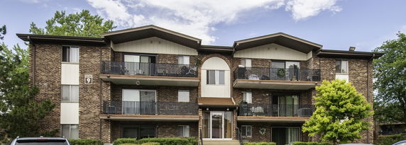 Front view of a multi-story brick building with balconies.
