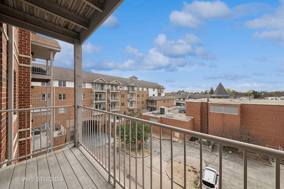 View of surrounding residential buildings from a balcony, featuring multiple floors and red brick exteriors.