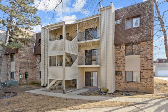 Front view of a multi-story apartment building with balconies and external staircases.