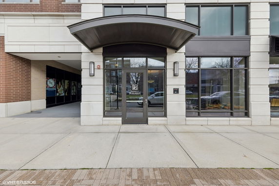 Front view of a modern commercial building entrance with glass doors and windows.