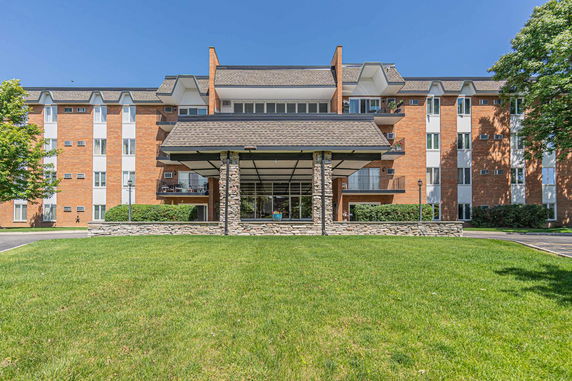 Front view of a multi-story building with brick facade and central entrance.