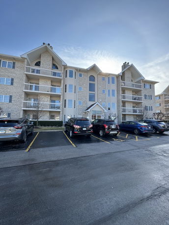 Front view of a multi-story apartment building with balconies.