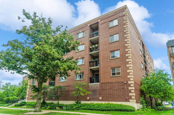 Front view of a multi-story brick apartment building.