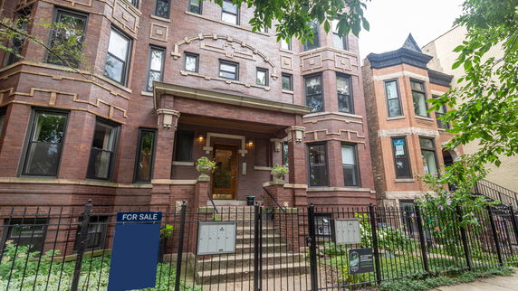 Front view of a multi-story brick building with ornate window designs.
