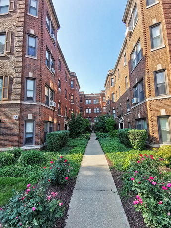 Pathway leading to a multi-story brick apartment building.
