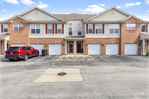 Front view of a multi-family townhouse building with garages.