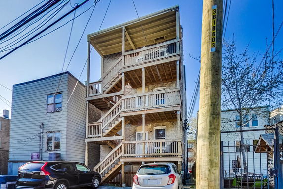 Rear view of a multi-story building with exterior wooden staircases.