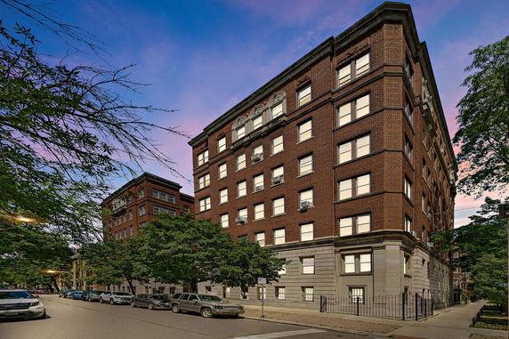 Front view of a multi-story brick building with numerous windows.