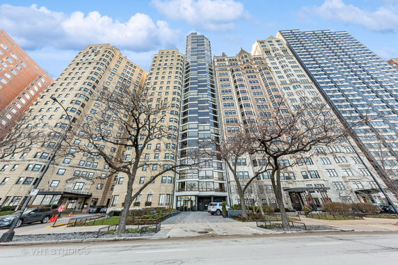Front view of a tall residential building with multiple sections and windows.