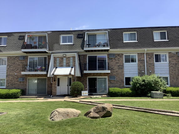 Front view of a three-story apartment building with balconies.