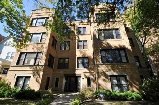 Front view of a multi-story brick building with multiple windows.