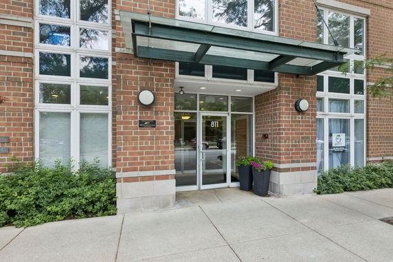 Front view of a brick building entrance with glass doors and windows.