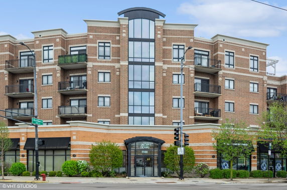 Front view of a multi-story brick apartment building with balconies.