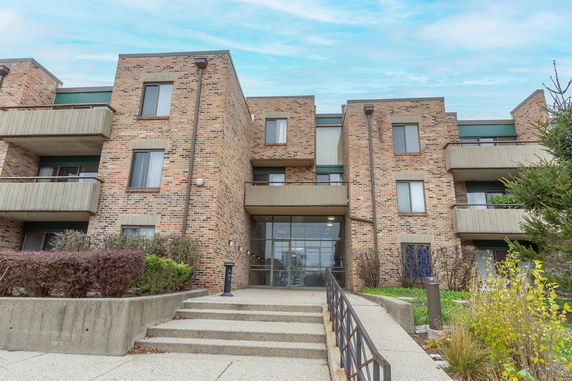 Front view of a multi-story brick building with balconies.