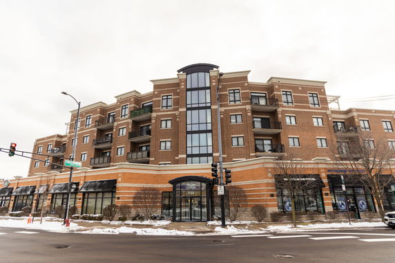 Front view of a multi-story brick building with balconies.