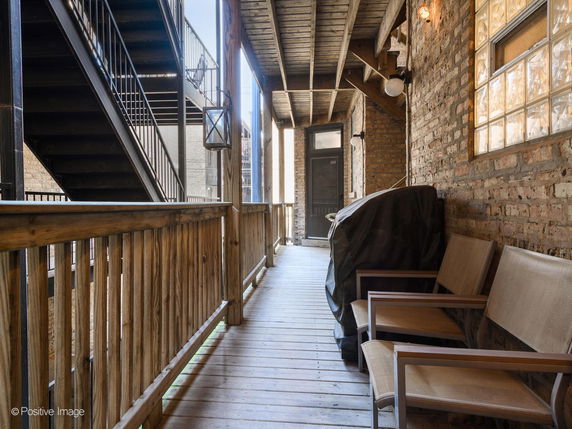 Outdoor wooden walkway with seating and stairs.